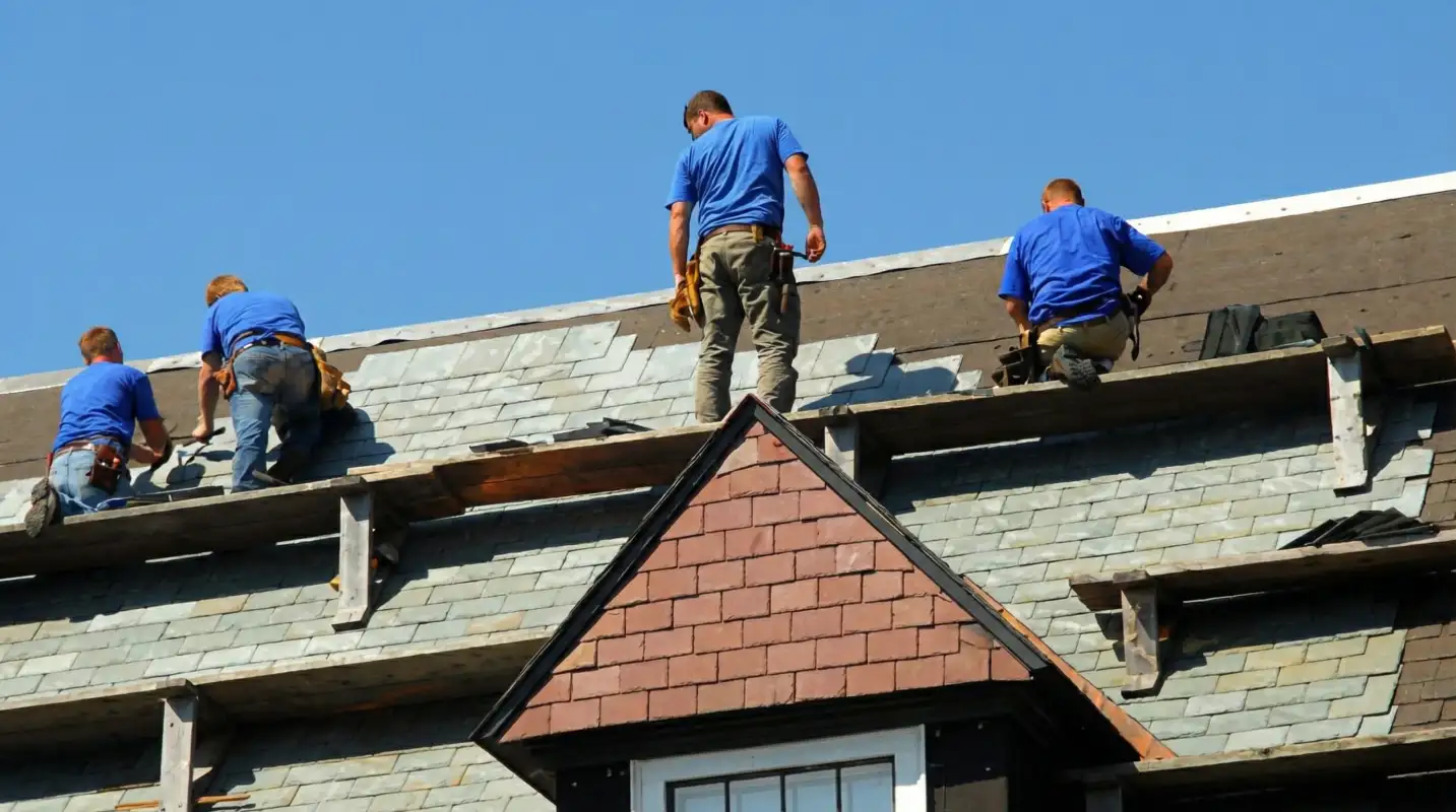 Roof replacement in progress with a team of professional contractors installing new shingles on a residential home in Anchorage, AK