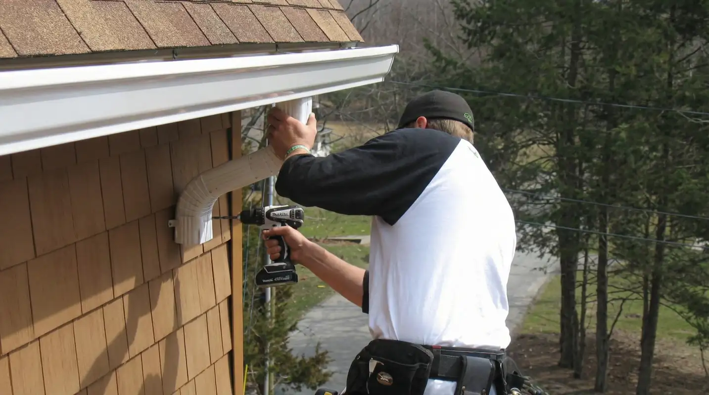 Professional contractor installing tan vinyl siding panels on a residential home exterior in Anchorage, AK